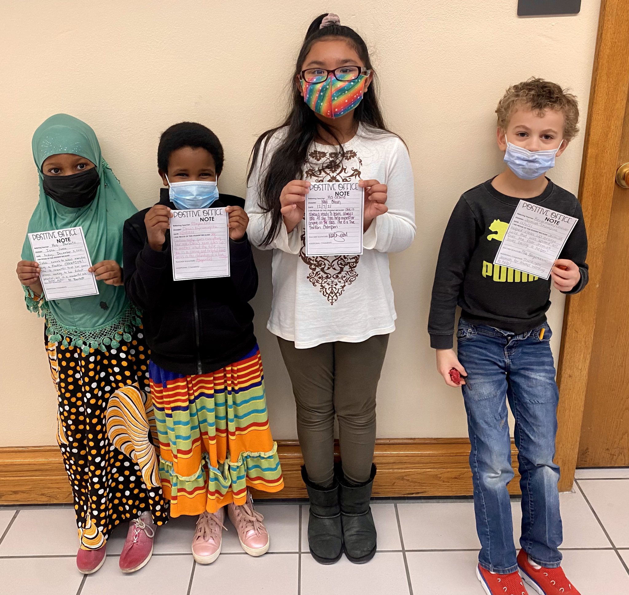 This is a photo of four Franklin students standing in a line, each holding a positive note that a teacher wrote for them. 