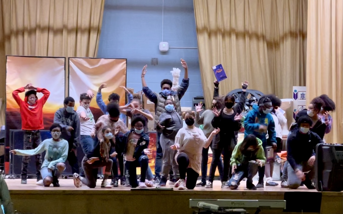 This is a photo of the cast of the Clary/ELMS musical, Aladdin. The students are gathered in several rows, standing on the school's stage.