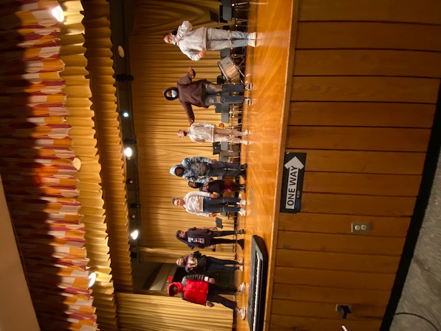 This is a photo of Lincoln Middle School students standing on their school stage during a rehearsal for The Lion King.