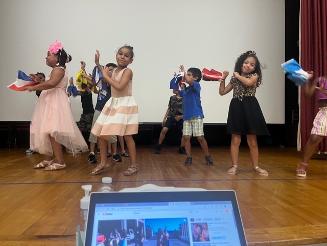 This is a photo of students dancing on a school stage.