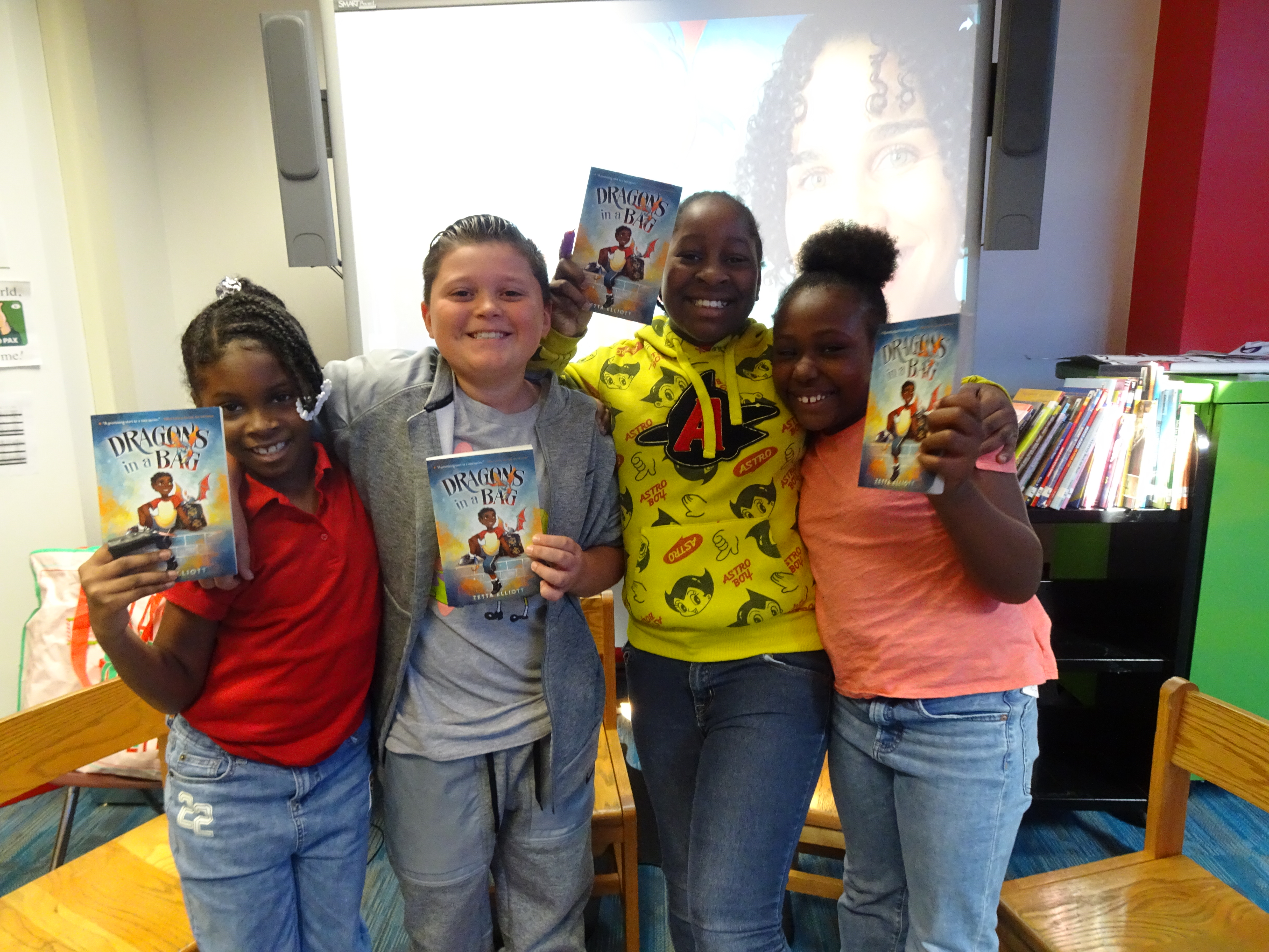 This is a photo of four scholars at Van Duyn, huddled together smiling, each holding a copy of their book.