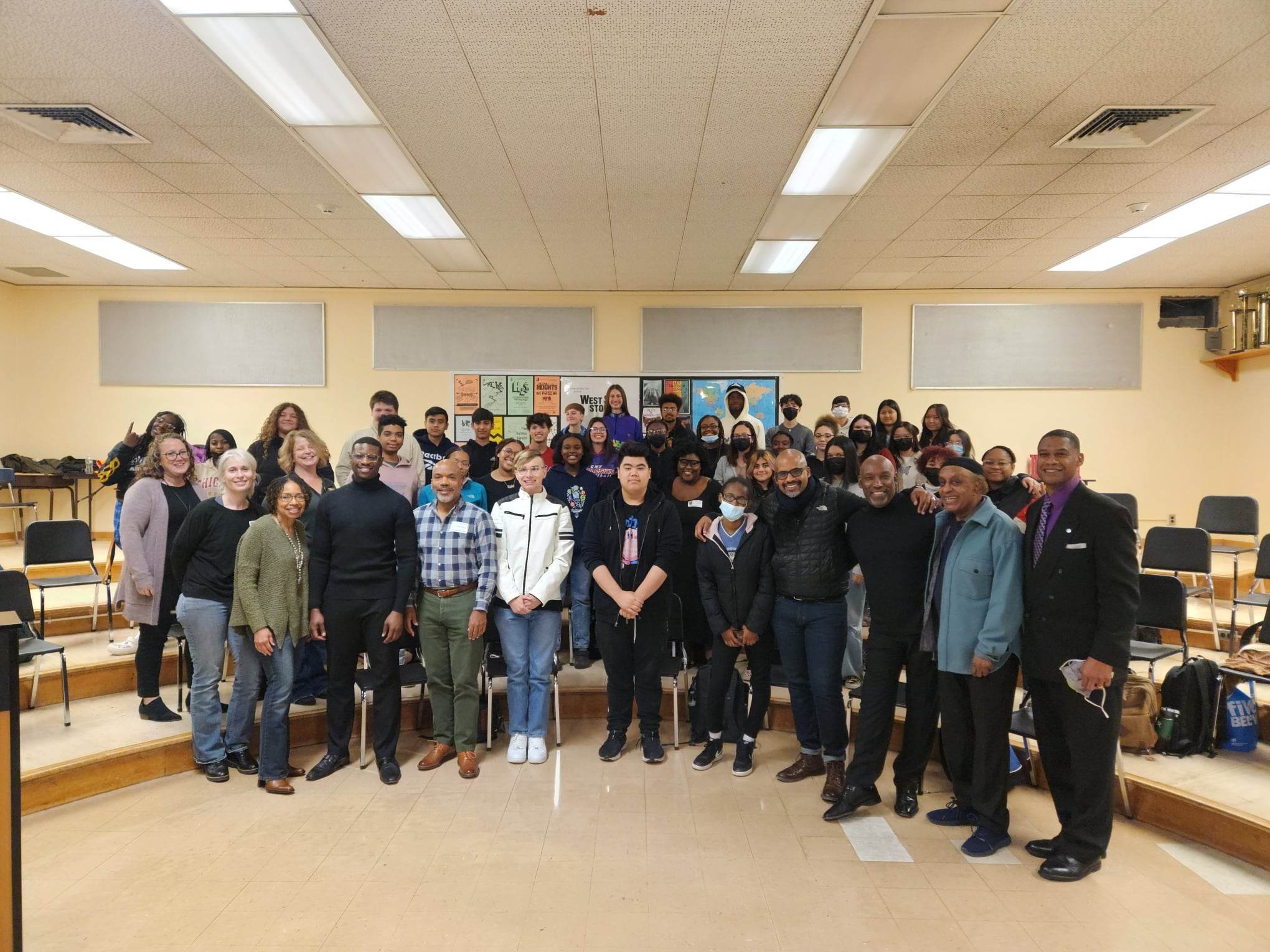 This is a photo of Syracuse Opera performers standing in a classroom with a group of Henninger music students.