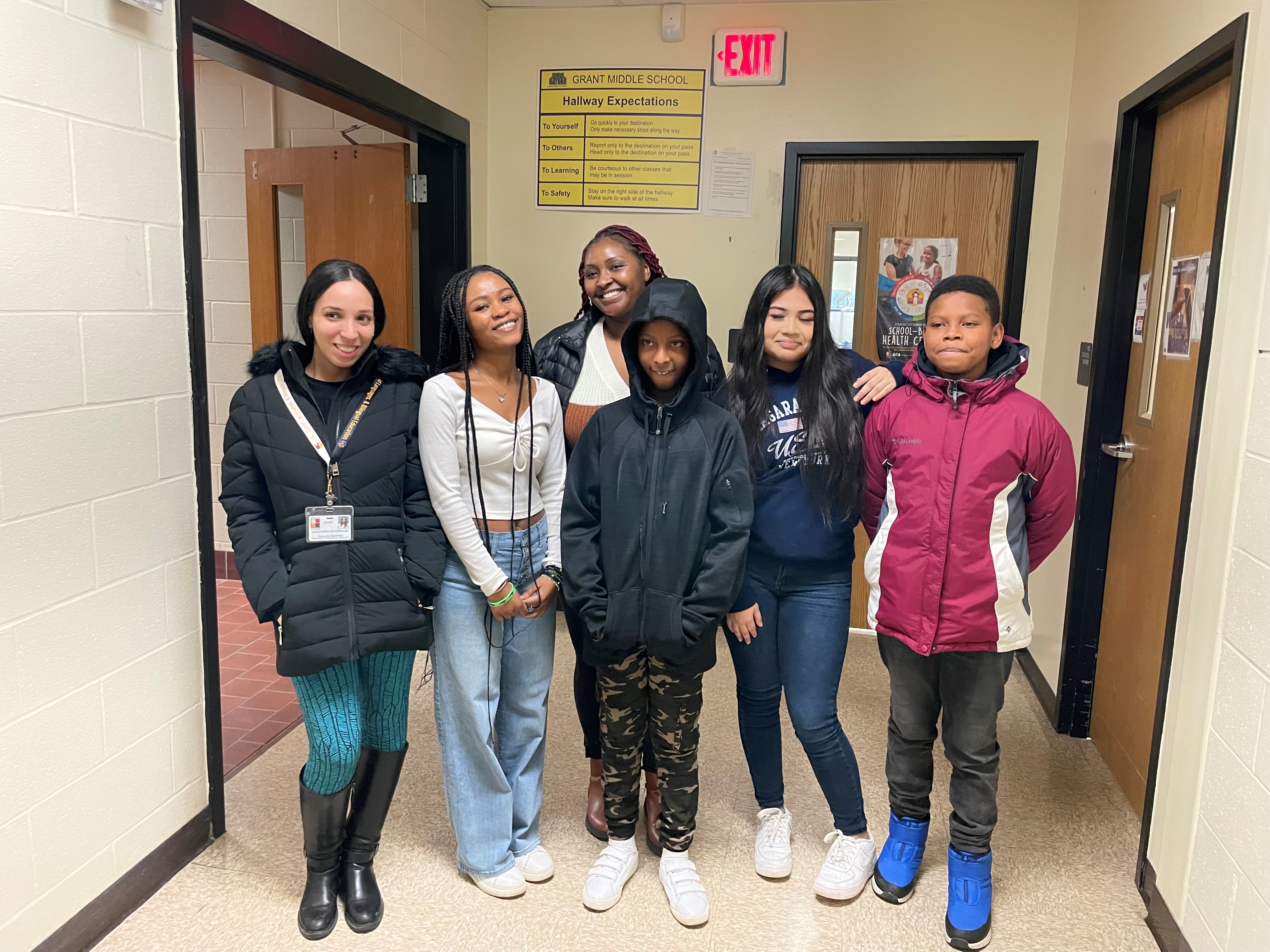 This is a photo of six Grant Middle School students standing in the hallway of their school posing for a photo.