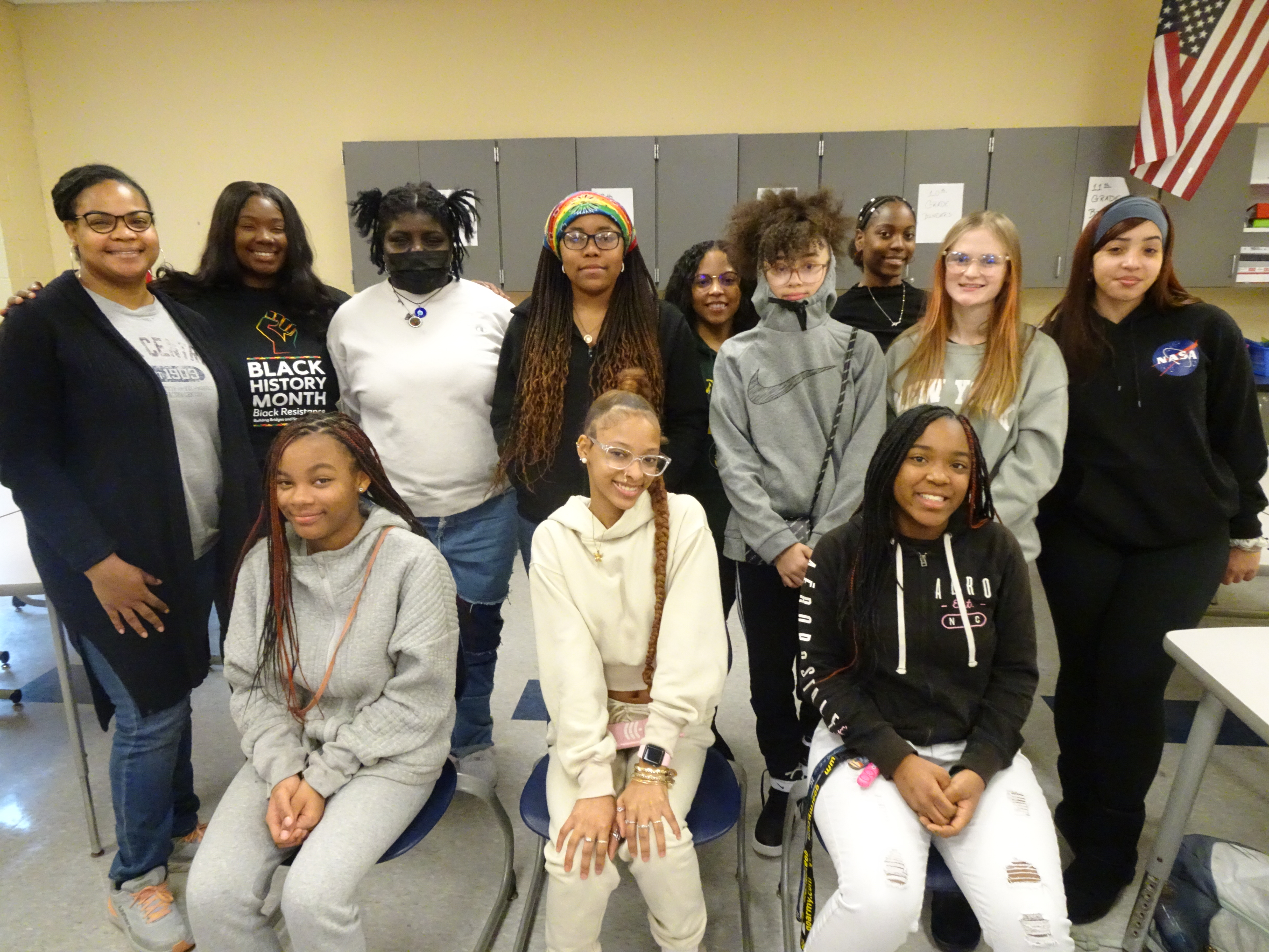 This is a group photo of female students gathered in a classroom at ITC, standing in two rows and smiling at the camera.