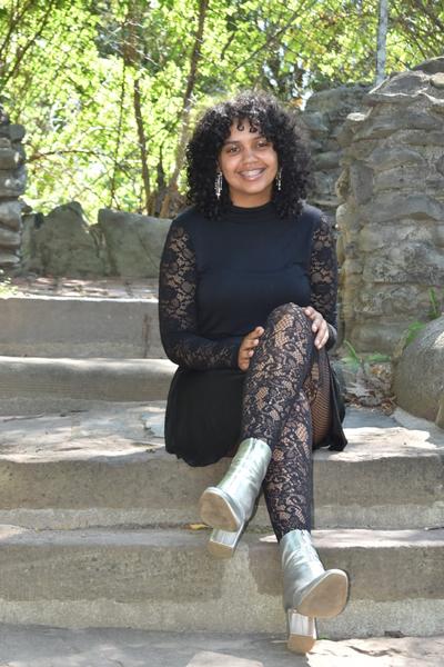 This is a photo of ITC student Serenity Baxter sitting on a rock smiling.