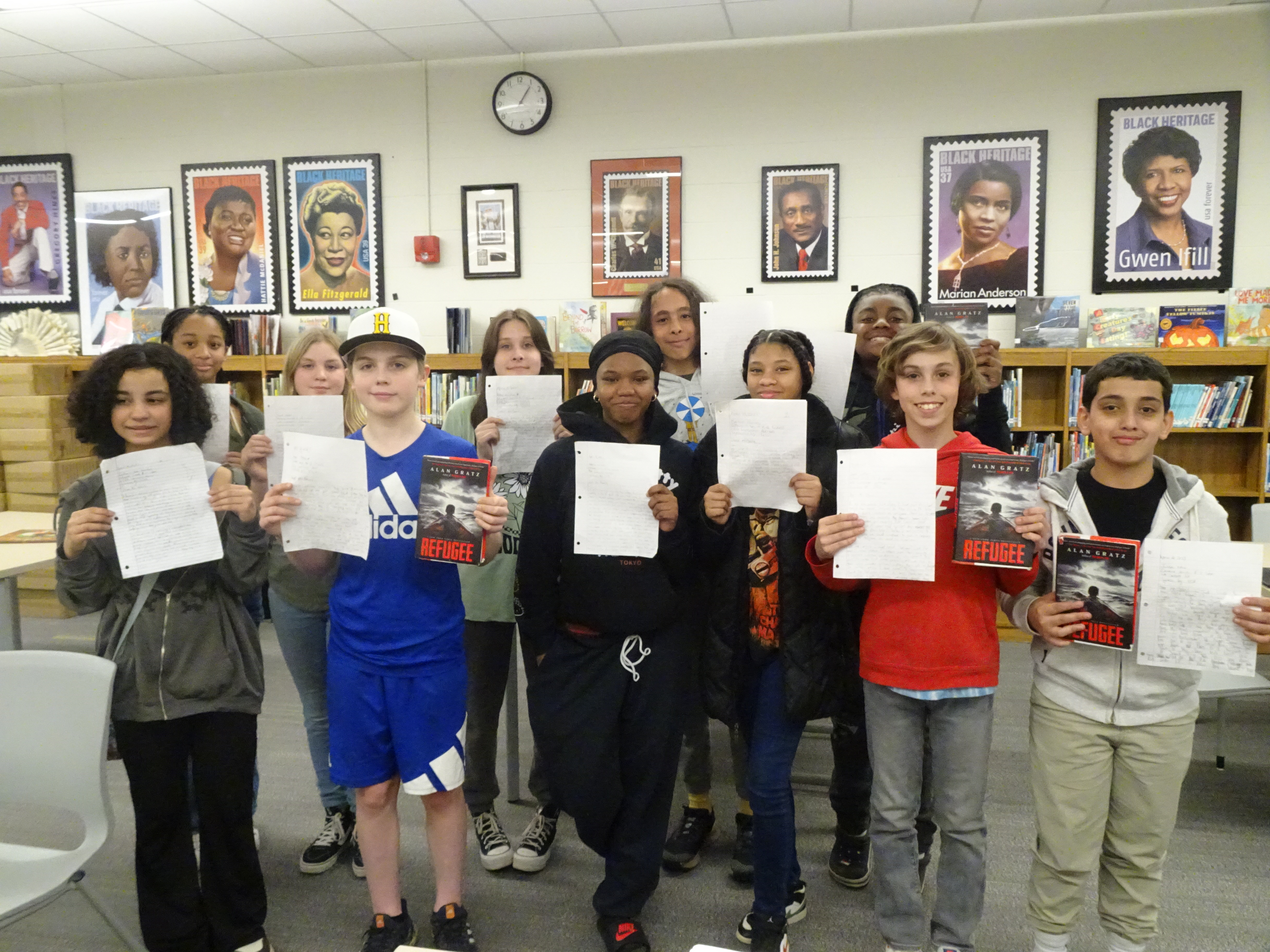 This is a photo of a group of Ed Smith students standing in their school library holding up letters they wrote to public officials.