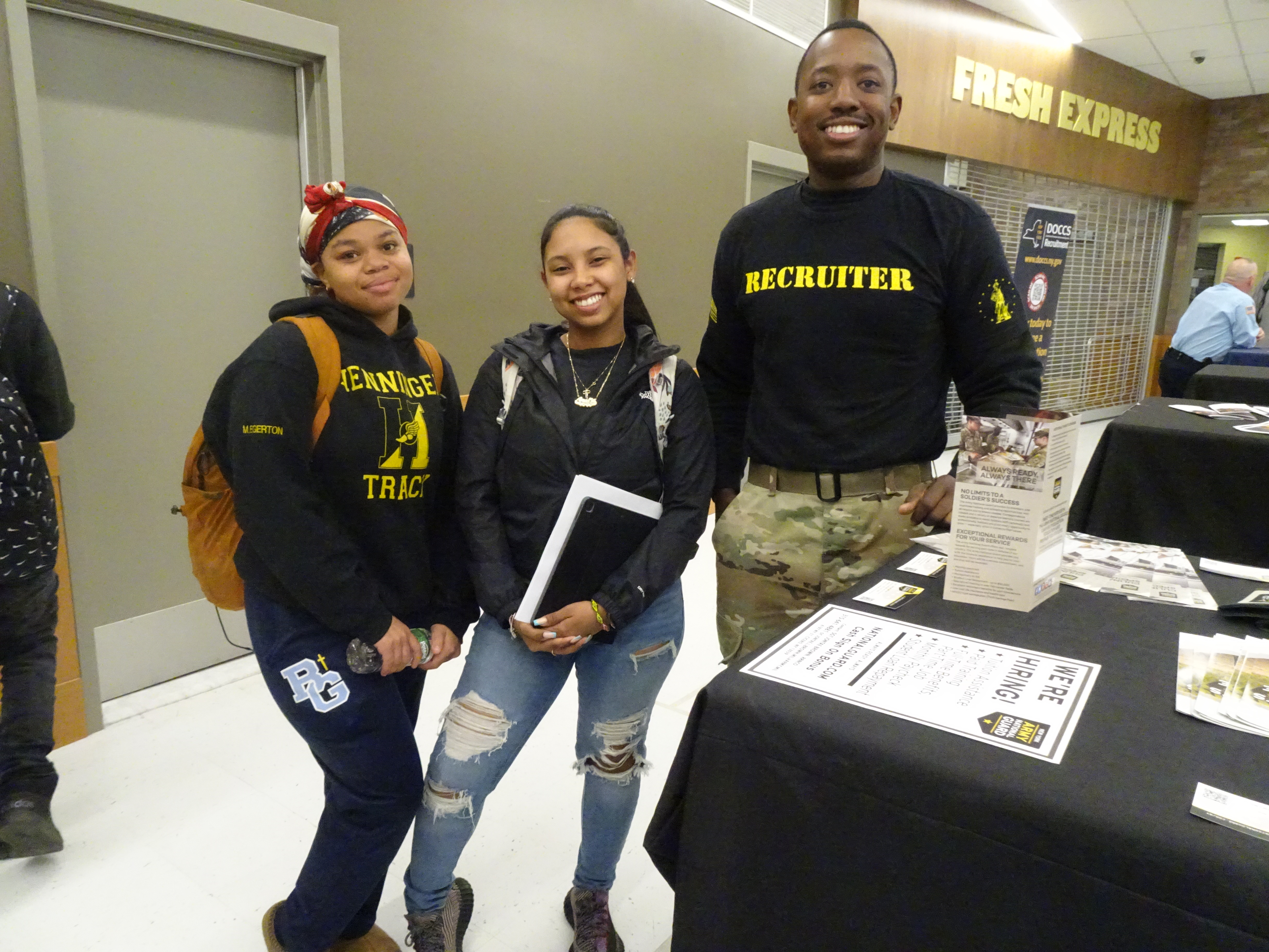 This is a photo of two Henninger students along with a recruiter, all smiling at the camera,  at the Henninger job fair.