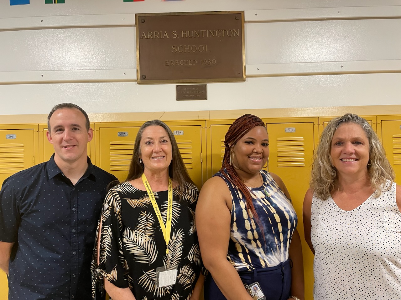 This is a photo of members of the Huntington School Student Support Team, standing in front of a row of lockers and smiling at the camera.