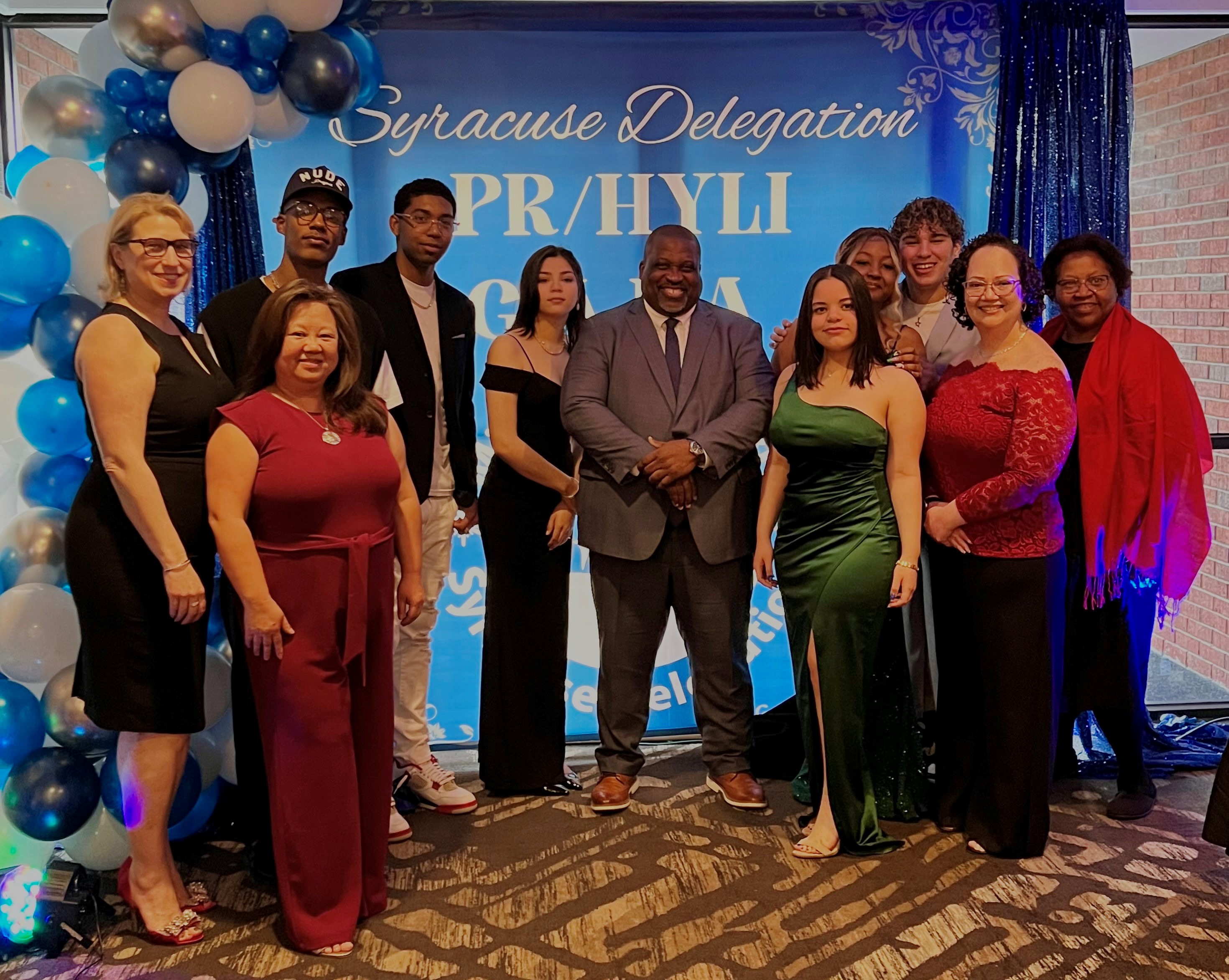 This is a photo of students and staff attending the PRHYLI Gala, wearing formal gear and smiling at the camera.