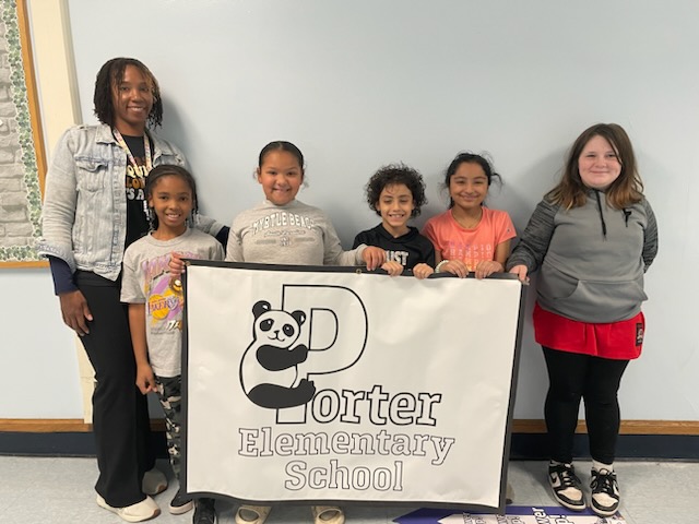 This is a photo of student representatives on the Porter Student Equity team, standing in the hallway and holding a sign that says 'Porter Elementary School.' 