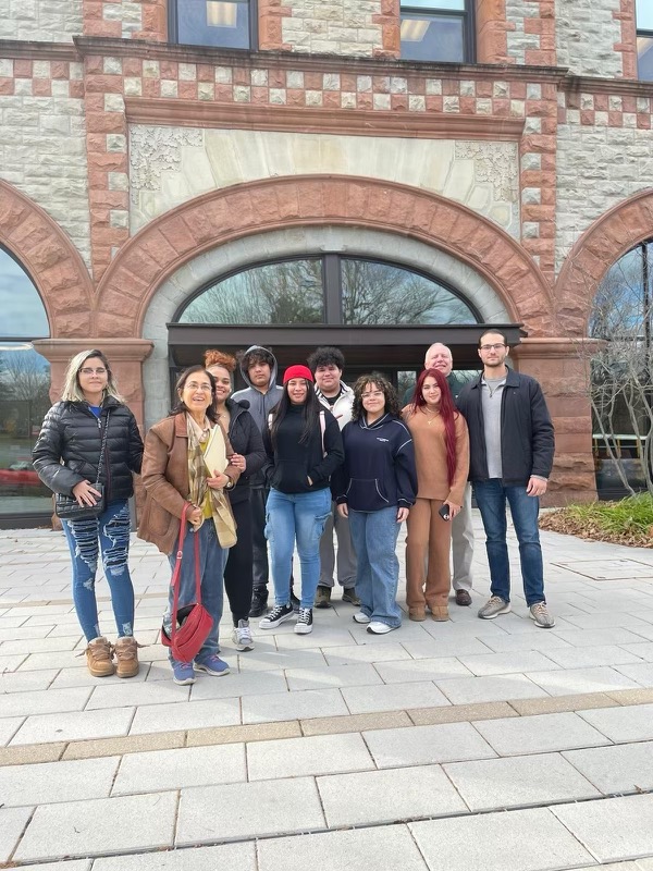 This is a photo of a group of Nottingham students and some professors outside a college building.