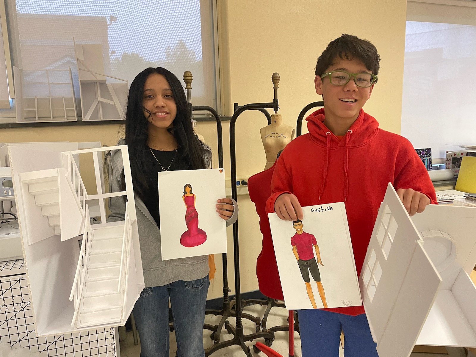 This is a photo of two Nottingham Creative Expression and Design students holding some of their class projects.