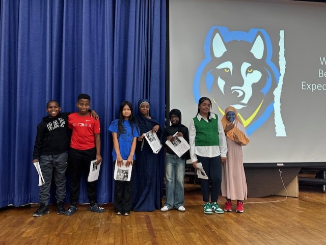 This is a photo of some Webster Student Council members standing on the school stage smiling at the camera.